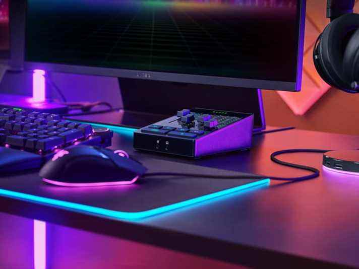 Le mélangeur audio Razer se trouve sur un bureau au milieu d'un moniteur, d'un clavier et d'une souris.