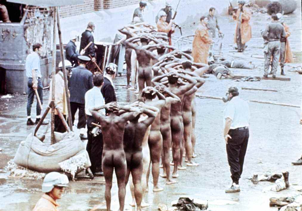 NOTE EDS : NUDITÉ Les prisonniers les mains sur la tête et dépouillés de tous leurs vêtements sont alignés après que les gardes ont repris le contrôle à la suite de l'émeute de la prison d'Attica à Attica, New York, septembre 1971. L'émeute, au cours de laquelle 43 personnes ont été tuées, a duré quatre jours au cours de laquelle des gardes ont été retenus en otage.  (AP Photo)