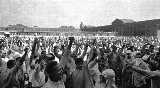 FILE - This Sept. 10, 1971 file photo shows inmates of Attica State Prison as they raise their hands in clenched fist salutes to voice their demands during a negotiating session with New York's prison Commissioner Russell Oswald. The whistleblower who spurred a major state investigation of alleged crimes and cover-ups at Attica prison is still on the case four decades later. Ex-prosecutor Malcolm Bell, now 82 and retired to the Green Mountains of Vermont, recently filed court papers in support of opening long-sealed investigation volumes. (AP Photo, File)