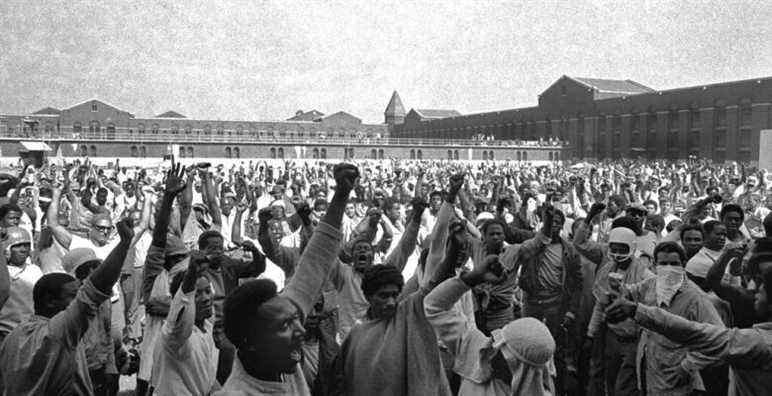FILE - This Sept. 10, 1971 file photo shows inmates of Attica State Prison as they raise their hands in clenched fist salutes to voice their demands during a negotiating session with New York's prison Commissioner Russell Oswald. The whistleblower who spurred a major state investigation of alleged crimes and cover-ups at Attica prison is still on the case four decades later. Ex-prosecutor Malcolm Bell, now 82 and retired to the Green Mountains of Vermont, recently filed court papers in support of opening long-sealed investigation volumes. (AP Photo, File)