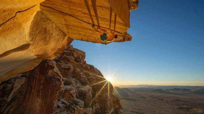 Alex Honnold escalade le bord d'une montagne au coucher du soleil dans The Soloist VR.