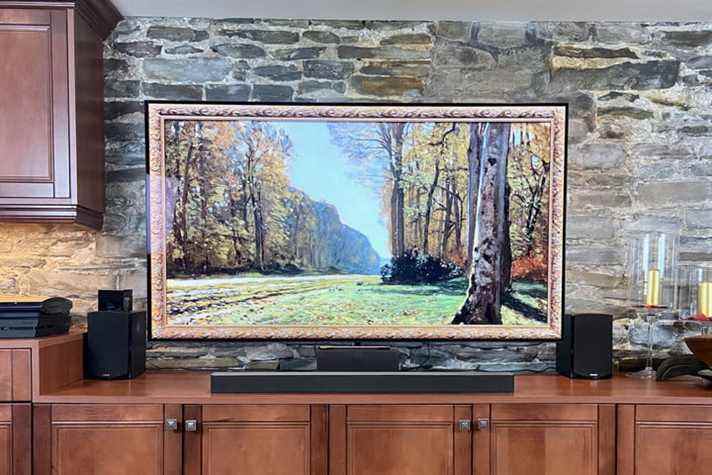 La barre de son Vizio M-Series 2.1 se trouve en dessous avec un téléviseur de 65 pouces affichant une œuvre d'art représentant des arbres.