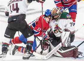 L'ailier droit des Canadiens de Montréal Brendan Gallagher (11) est enfoncé dans l'épaule du gardien de but des Coyotes de l'Arizona Karel Vejmelka (70) lors de la 2e période d'action de la LNH au Centre Bell de Montréal le mardi 15 mars 2022.