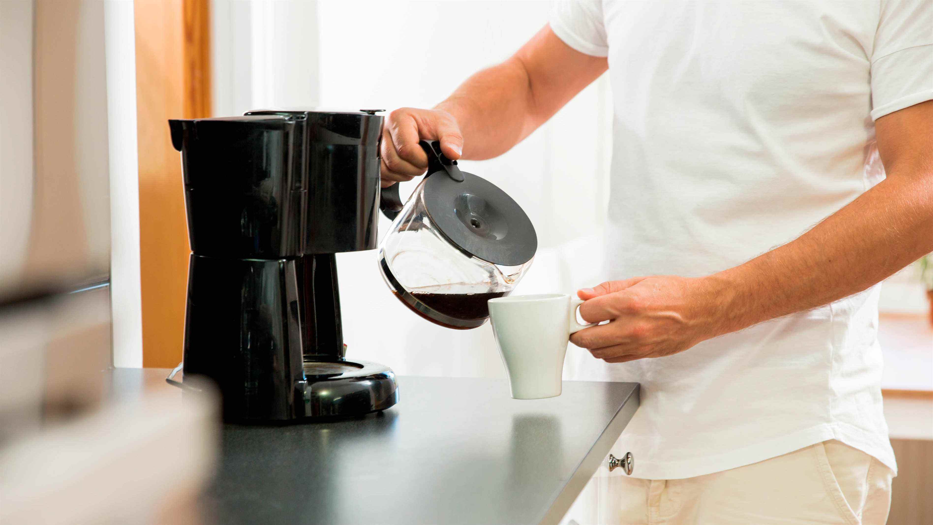 Une cafetière versant du café frais dans une tasse