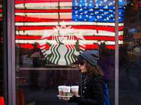 Une femme sort du café d'un magasin Starbucks dans le quartier de Manhattan à New York.