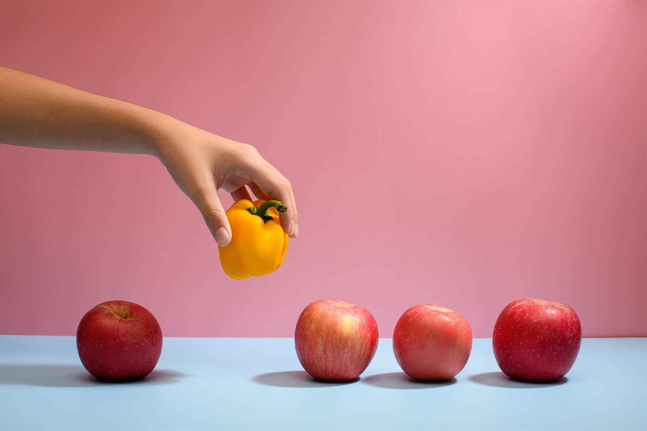 Cueillir à la main un poivron jaune se démarquant des pommes