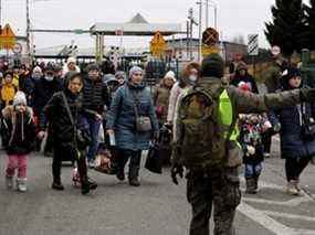 Des personnes venant d'Ukraine traversent la frontière ukraino-polonaise à Korczowa, en Pologne, le samedi 5 mars 2022.