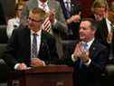 Le ministre des Finances de l'Alberta, Travis Toews, à gauche, est applaudi par le premier ministre Jason Kenney après que Toews a présenté son budget à l'Assemblée législative de l'Alberta à Edmonton le 24 octobre 2019.