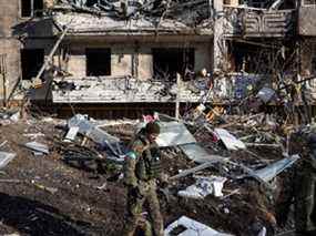 Un soldat ukrainien inspecte les décombres d'un immeuble détruit à Kiev le 15 mars, après que des frappes contre des zones résidentielles ont tué au moins deux personnes.