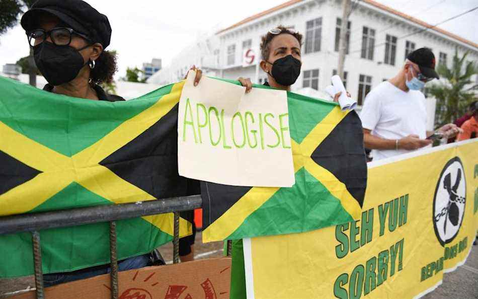 Des personnes appelant à des réparations pour l'esclavage manifestent devant l'entrée du haut-commissariat britannique lors de la visite du duc et de la duchesse de Cambridge à Kingston le 22 mars - RICARDO MAKYN/AFP