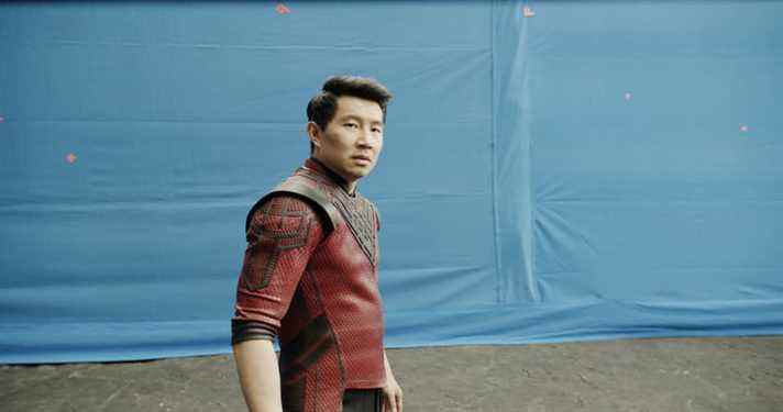 Simu Liu devant un écran bleu pendant le tournage de Shang-Chi et la légende des dix anneaux.