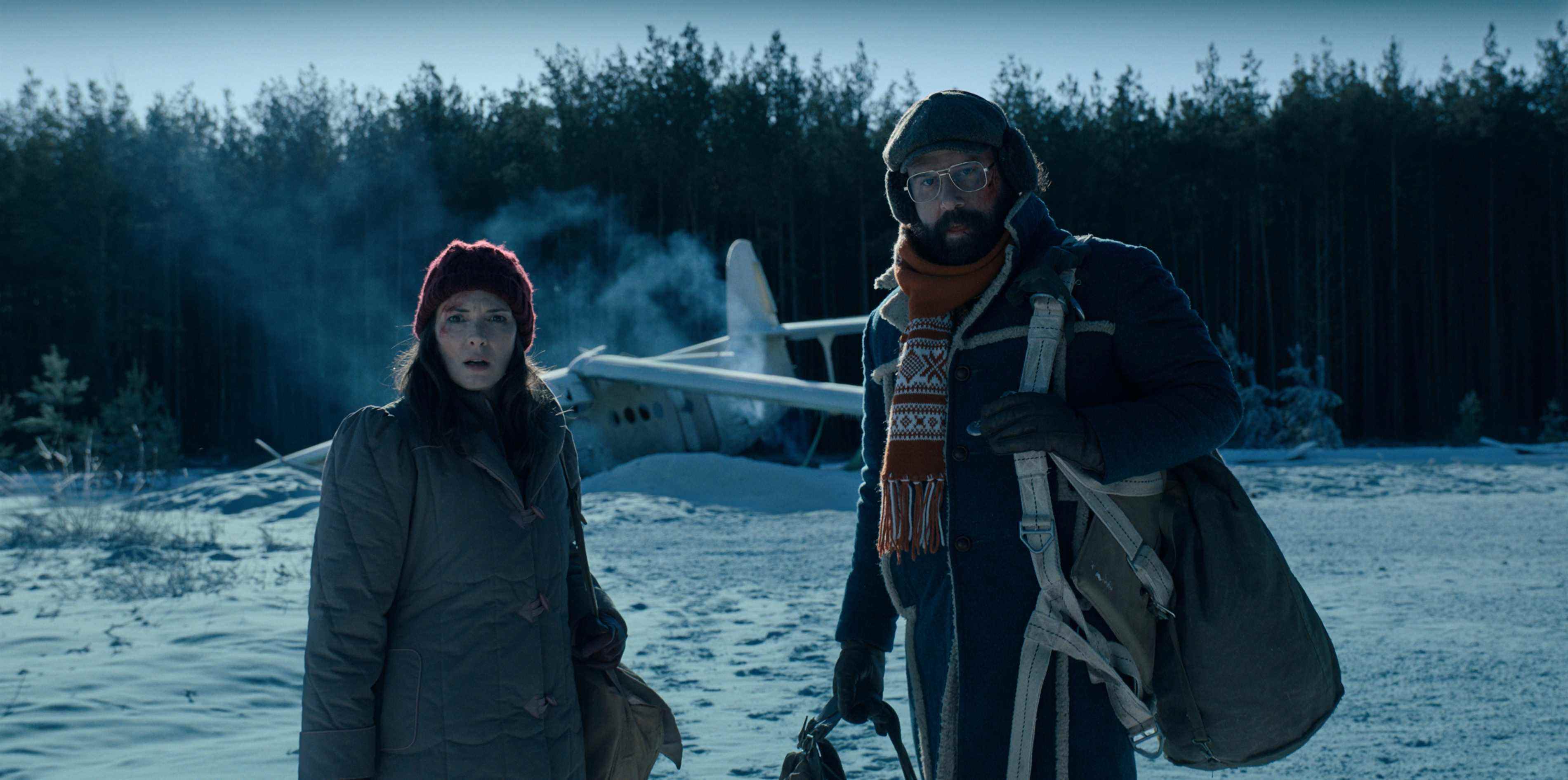 Joyce (Winona Ryder) et Murray (Brett Gelman) à l'extérieur d'un avion écrasé dans une scène enneigée dans une image officielle de la saison 4 de Stranger Things