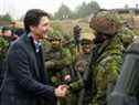 Le premier ministre Justin Trudeau rend visite aux membres des troupes canadiennes, à la suite de l'invasion russe de l'Ukraine, dans la base militaire d'Adazi, en Lettonie, le 8 mars 2022. 