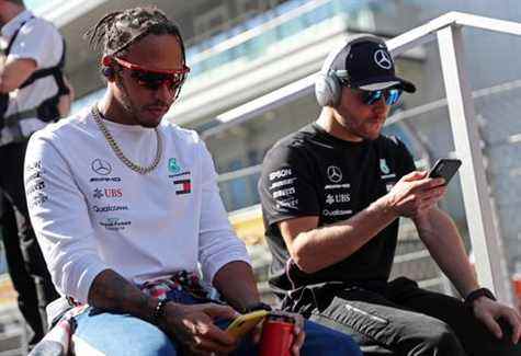 lewis hamilton et valtteri bottas, pilotes de formule 1 mercedes, s'assoient ensemble en regardant leurs téléphones avant un grand prix