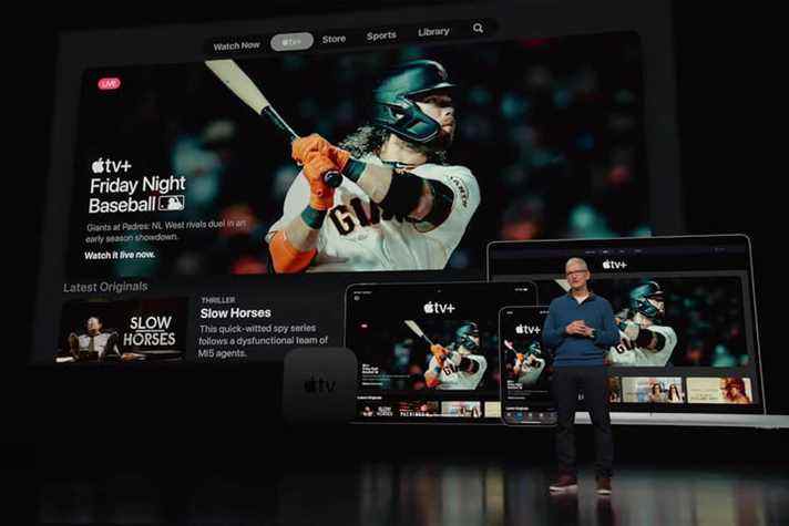 Le PDG d'Apple, Tim Cook, fait une présentation devant un écran mettant en évidence les offres de baseball d'Apple TV+.