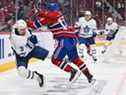Nick Suzuki des Canadiens de Montréal assène un coup sûr à Justin Holl des Maple Leafs de Toronto lors de la deuxième période au Centre Bell le 21 février 2022 à Montréal.