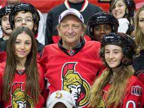 Le propriétaire des Sénateurs d'Ottawa, Eugene Melnyk, est entouré d'enfants, dont ses filles à ses côtés Anna (à gauche) et Olivia (à droite), alors qu'il accueille environ 100 écoliers locaux au Centre Canadian Tire pour son 12e « Eugene Melnyk Skate for Kids » en 2019.
