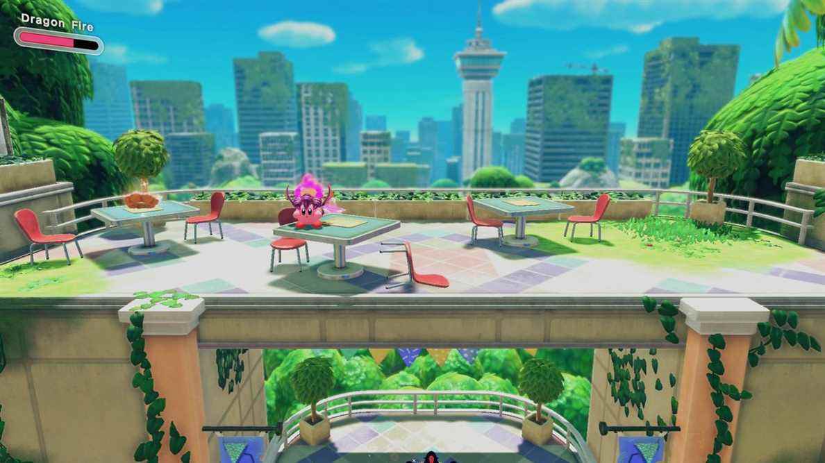 Kirby se tient sur une table au-dessus d'une arche près d'un beignet flottant.
