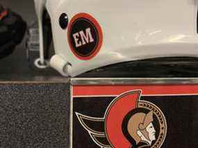 Les Sénateurs d'Ottawa avaient des décalcomanies EM sur leurs casques le mardi 29 mars 2022, un jour après le décès du propriétaire de l'équipe, Eugene Melynk.