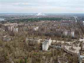 Une nouvelle structure de confinement sûr (NSC) au-dessus de l'ancien sarcophage recouvrant le quatrième réacteur endommagé de la centrale nucléaire de Tchernobyl est vue derrière la ville abandonnée de Pripyat, en Ukraine, le 12 avril 2021.