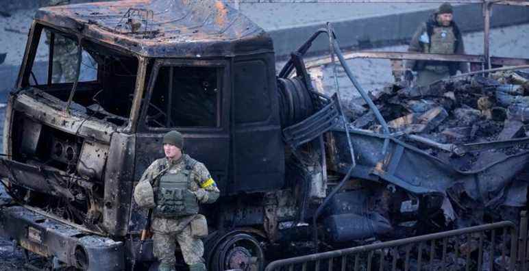 Ukrainian troops inspect the site following a Russian airstrike in Kyiv, Ukraine, Saturday, Feb. 26, 2022. (AP Photo/Vadim Ghirda)