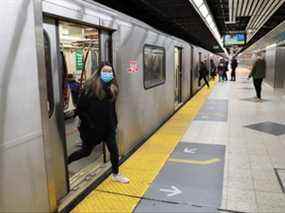 Une femme portant un masque sort d'une rame de métro à Toronto le 17 mars 2020.