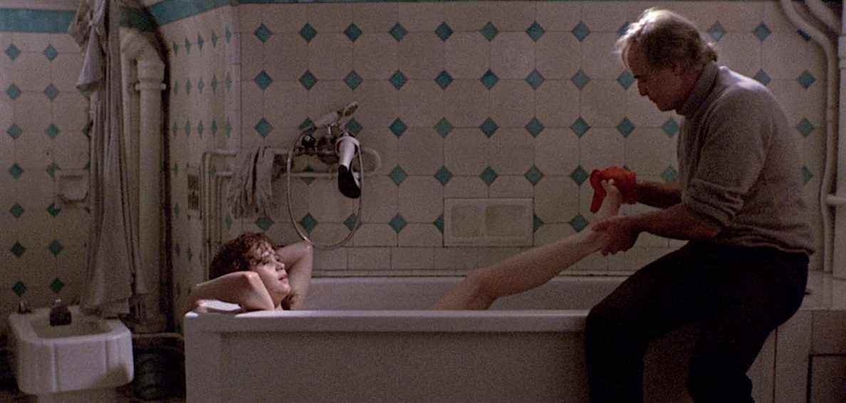 Maria Schneider est allongée dans une baignoire pendant que Marlon Brando se lave les pieds dans Dernier Tango à Paris