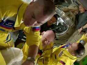 Les cosmonautes russes Oleg Artemyev, Denis Matveev et Sergey Korsakov arrivent vêtus de combinaisons de vol jaunes et bleues à la Station spatiale internationale après avoir amarré leur capsule Soyouz le 18 mars.