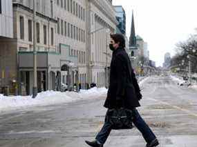 Le premier ministre Justin Trudeau traverse une rue Wellington vide pour assister à une conférence de presse à Ottawa, Ontario, Canada, le 21 février 2022.