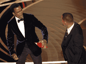 Chris Rock réagit après avoir été frappé par Will Smith (R) alors que Rock parlait sur scène lors de la 94e cérémonie des Oscars à Hollywood, Californie, le 27 mars 2022.