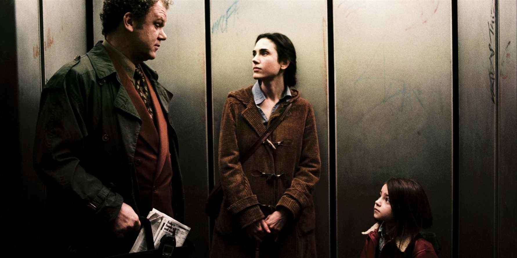 John C. Reilly, Jennifer Connelly et Ariel Gade debout dans un ascenseur à Dark Water