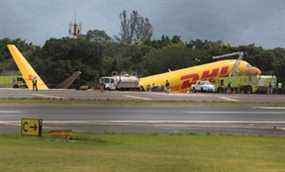Les pompiers travaillent sur les lieux où un avion cargo Boeing 757-200 exploité par DHL a effectué un atterrissage d'urgence avant de déraper de la piste et de se séparer, ont déclaré les autorités de l'aviation, à l'aéroport international Juan Santamaria d'Alajuela, Costa Rica, le 7 avril 2022.