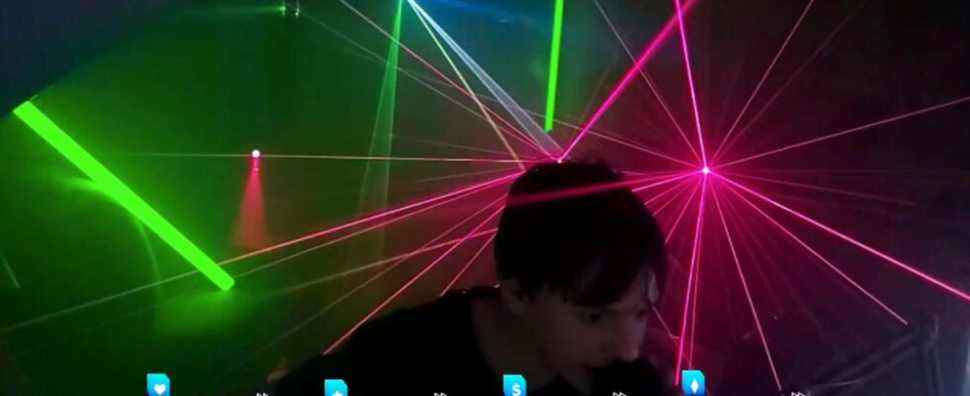 teenager crossmauz leans into his mic as lasers go off behind him