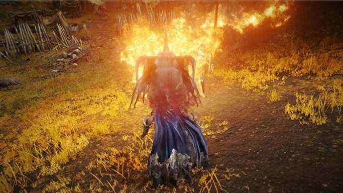 Le joueur de l'Elden Ring utilise le feu du dragon sur la colline qui regarde l'arbre d'erd