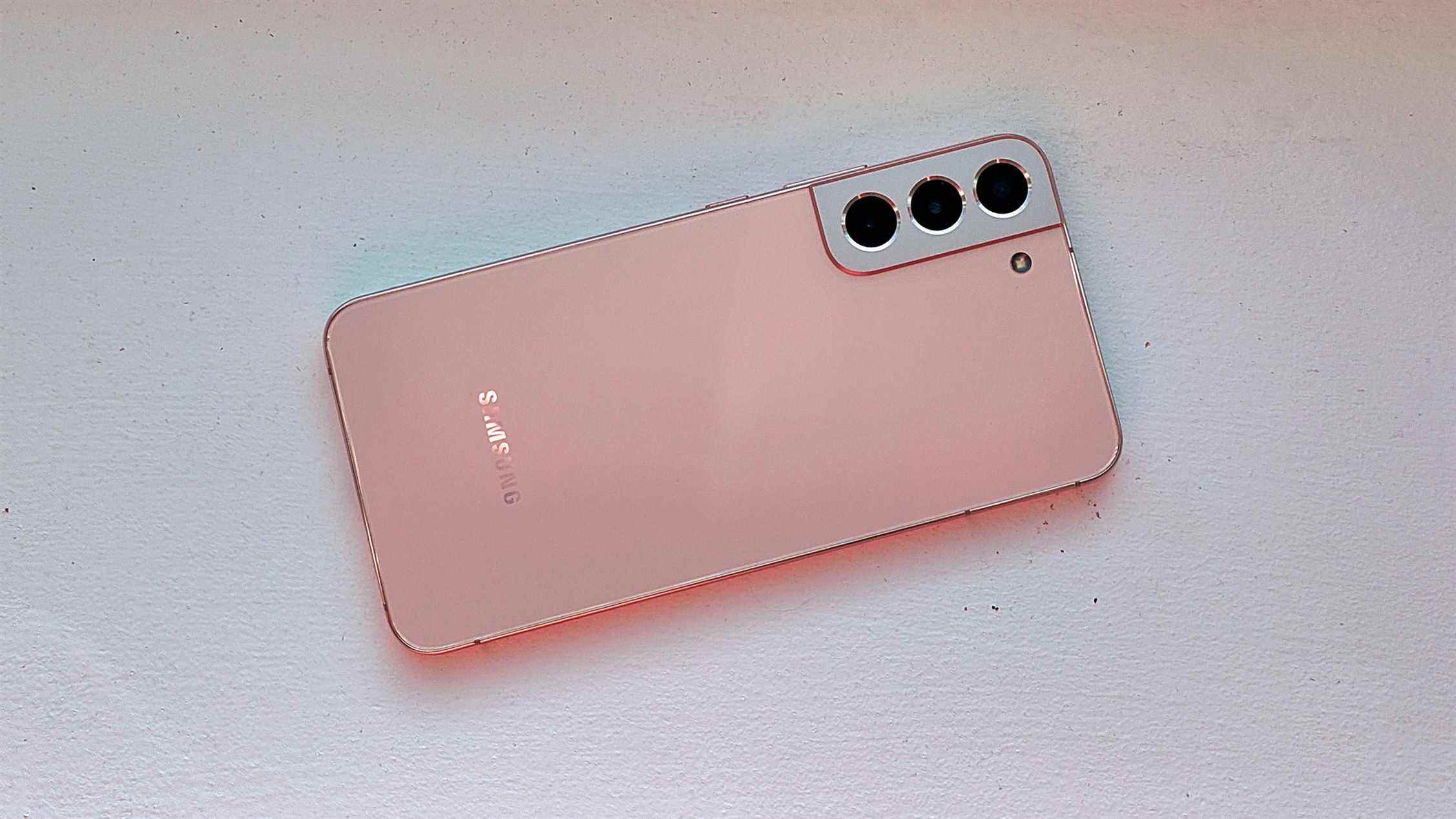 Un Samsung Galaxy S22 Plus rose de l'arrière sur une surface blanche