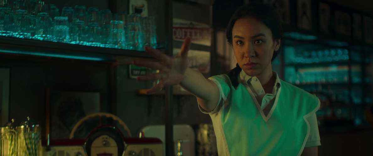 Ioanna Kimbook dans le rôle de Grace fait un geste dramatique de la main tendue dans une autre scène sombre et sombre de Choisir ou mourir de Netflix.
