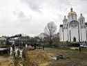 Des enquêteurs ukrainiens exhument des corps d'une fosse commune dans l'enceinte de l'église Saint-André de la ville de Bucha, au nord-ouest de Kiev, le 8 avril 2022.