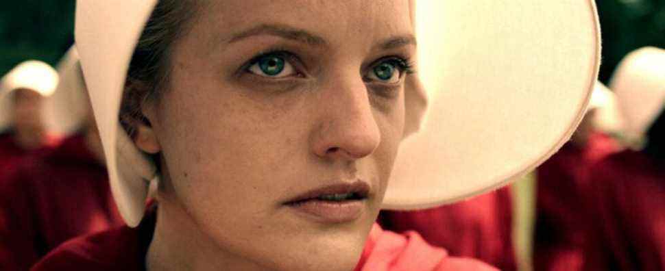 Elisabeth Moss in the handmaids outfit looks up