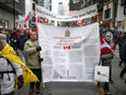 Des manifestants portant une copie de la Charte canadienne des droits et libertés défilent dans la rue Yonge alors que les camionneurs et leurs partisans continuent de protester contre les mandats de vaccination contre la maladie à coronavirus (COVID-19), à Toronto, Ontario, Canada, le 12 février 2022. REUTERS/Nick Iwanyshyn 
