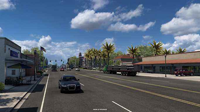 American Truck Simulator Texas - Une route à cinq voies avec des voitures et des camions traverse une zone commerciale avec des palmiers.