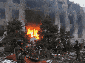 Des troupes pro-russes, dont des combattants de l'unité des forces spéciales tchétchènes, se tiennent devant le bâtiment administratif détruit d'Azovstal Iron and Steel Works dans la ville portuaire méridionale de Marioupol, en Ukraine, le 21 avril.