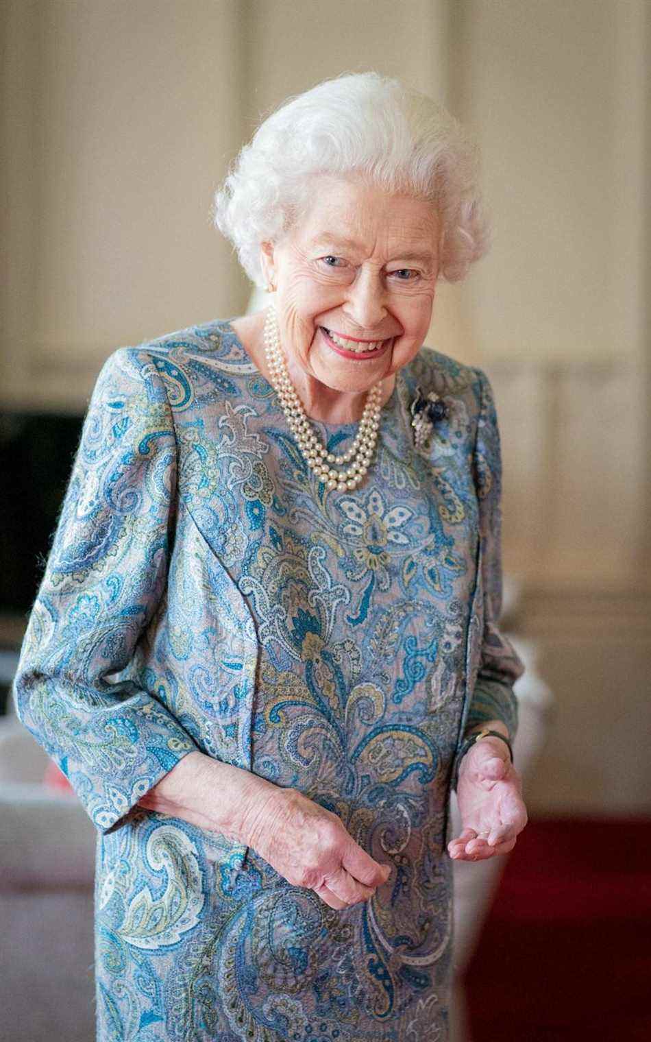 Sa Majesté dans une robe en soie à motifs cachemire bleu et gris, avec une broche en saphir et diamants sur le thème des fruits - Dominic Lipinski/AFP via Getty Images 