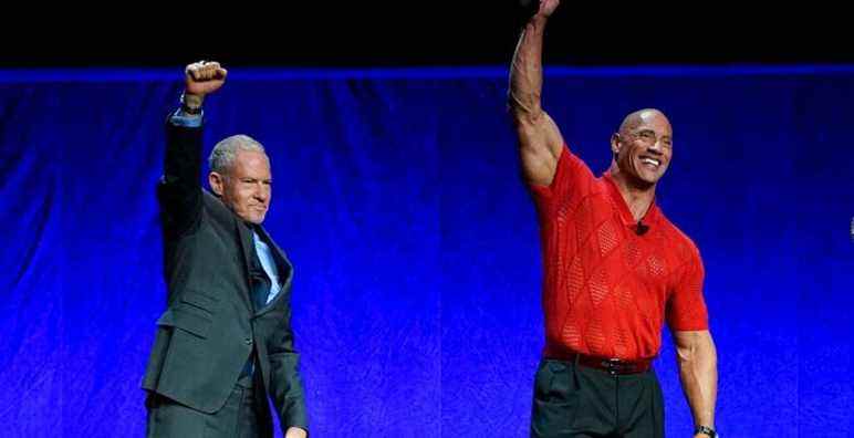 Toby Emmerich, left, chairman of the Warner Bros. Pictures Group, and Dwayne Johnson react to the audience after Emmerich handed Johnson the CinemaCon "Entertainment Icon of the Decade" award during the Warner Bros. Pictures presentation at CinemaCon 2022 at Caesars Palace, Tuesday, April 26, 2022, in Las Vegas. (AP Photo/Chris Pizzello)