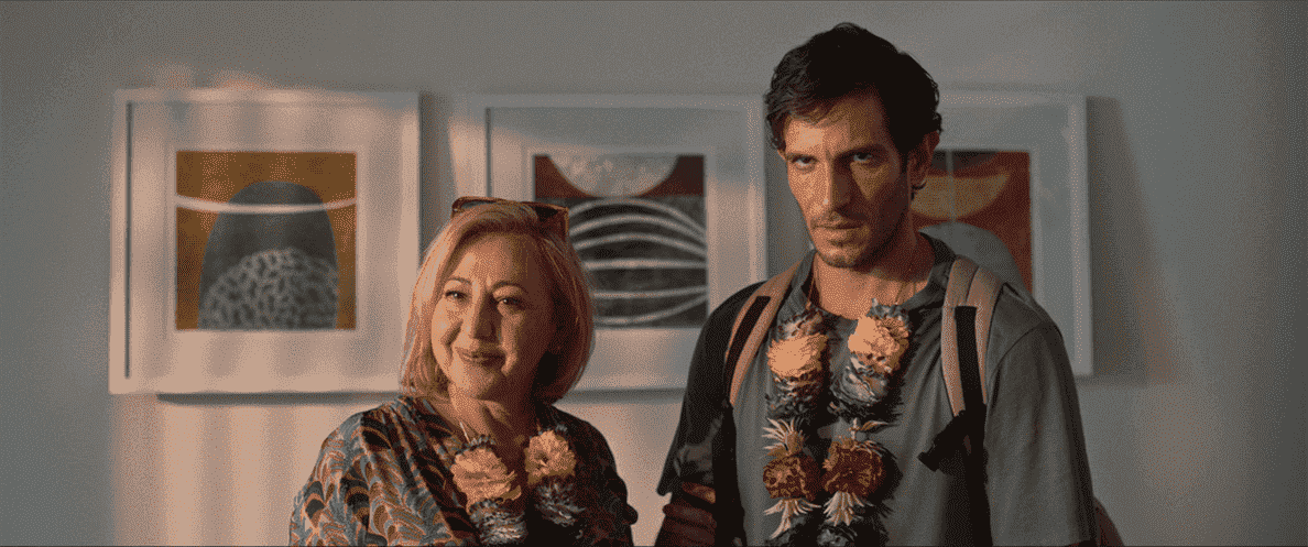 Mari (Carmen Machi) et son fils adulte José Luís (Quim Gutiérrez) portant des colliers de fleurs lei dans Honeymoon With My Mother.