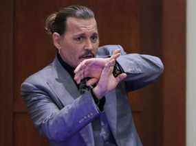 L'acteur Johnny Depp démontre comment il prétend s'être protégé d'une attaque présumée de son ex-femme Amber Heard alors qu'il témoigne lors de son procès en diffamation contre Heard, au palais de justice du comté de Fairfax à Fairfax, en Virginie, le mercredi 20 avril 2022.