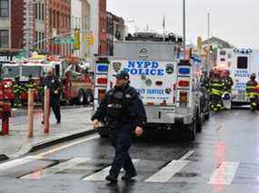 Des membres du département de police de New York et du personnel d'urgence envahissent les rues près d'une station de métro à New York le 12 avril 2022.