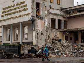 Un homme passe devant le bâtiment de l'Institut régional de Kharkiv de l'Académie nationale d'administration publique qui a été détruit lors des bombardements russes à Kharkiv, en Ukraine, le 12 avril 2022.