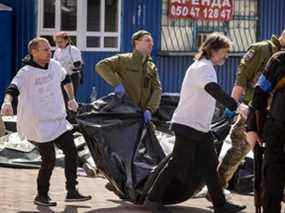 Des soldats ukrainiens vident des corps dans des sacs après qu'une attaque à la roquette a tué des dizaines de personnes dans une gare de Kramatorsk, en Ukraine, le vendredi 8 avril 2022.