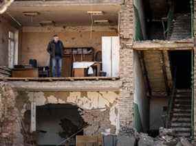 Un homme se tient dans un bâtiment à la façade effondrée du complexe militaro-industriel de la société Vizar, après que le site a été touché par des frappes russes nocturnes, dans la ville de Vyshneve, dans la banlieue sud-ouest de Kiev, le 15 avril 2022.