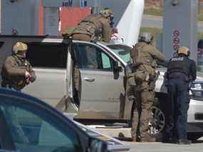 Des agents de la GRC se préparent à arrêter une personne dans une station-service à Enfield, en Nouvelle-Écosse, le dimanche 19 avril 2020.